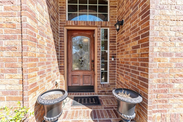 doorway to property featuring brick siding