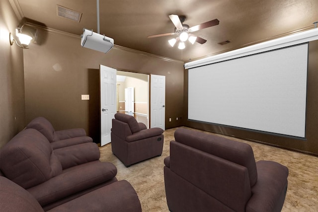 home theater with ornamental molding, visible vents, and a ceiling fan