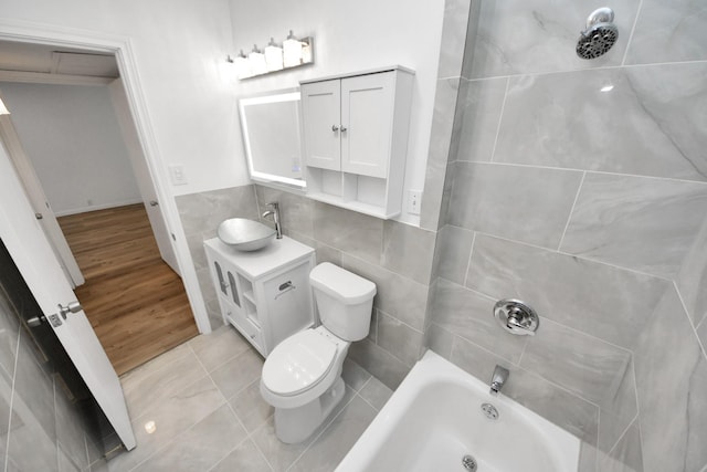 full bathroom featuring toilet, vanity, and tile walls