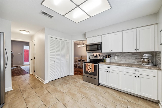 kitchen featuring visible vents, baseboards, white cabinets, appliances with stainless steel finishes, and tasteful backsplash