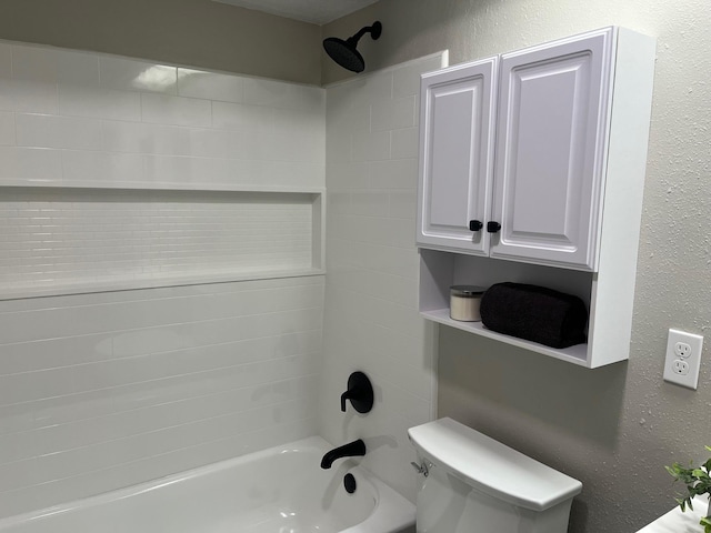 full bath featuring toilet, washtub / shower combination, and a textured wall