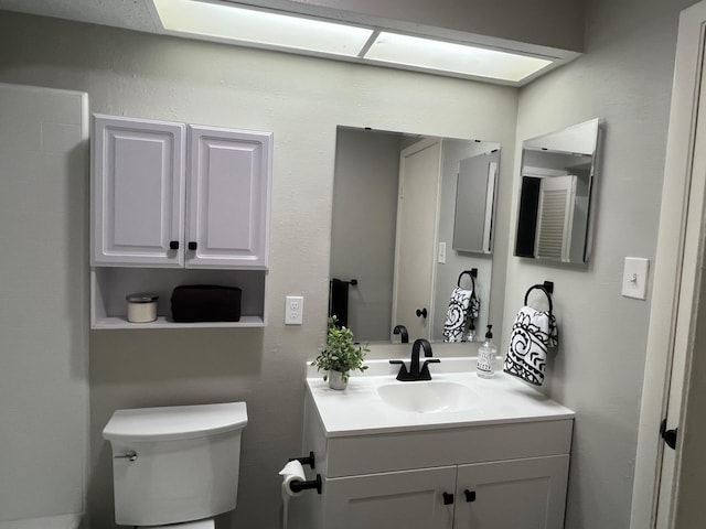 half bathroom featuring toilet and vanity