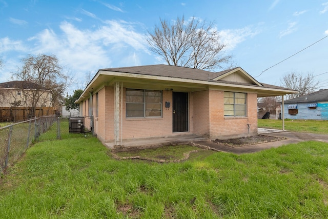 view of front of property featuring brick siding, a front lawn, central AC unit, and fence