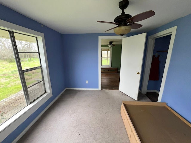 unfurnished room featuring a ceiling fan and baseboards