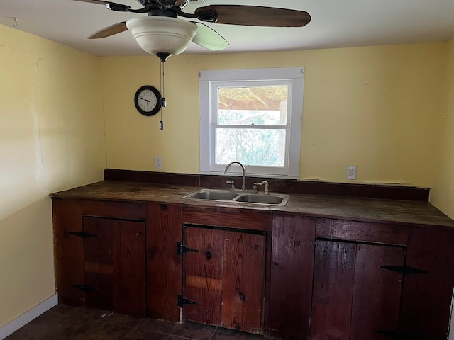 kitchen featuring dark countertops, a sink, and a ceiling fan