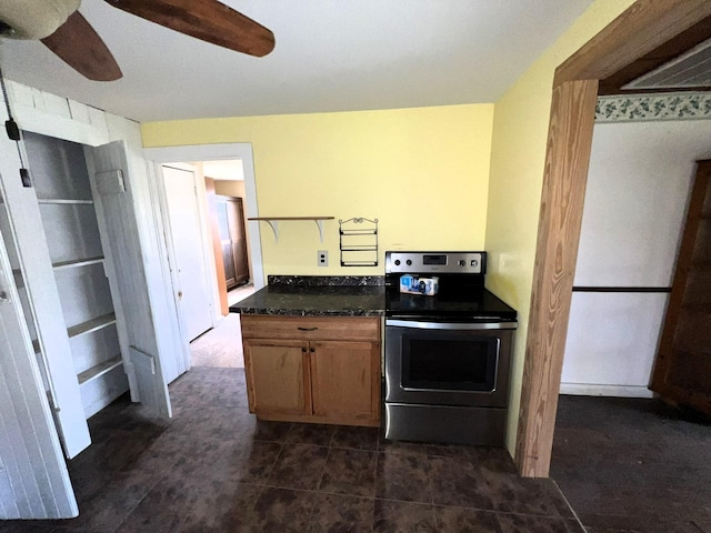 kitchen with ceiling fan, stainless steel range with electric stovetop, and brown cabinets