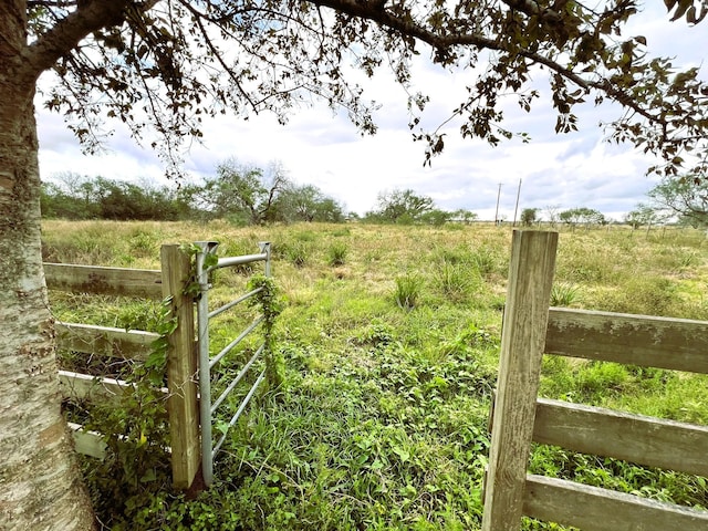 view of yard with a rural view and fence