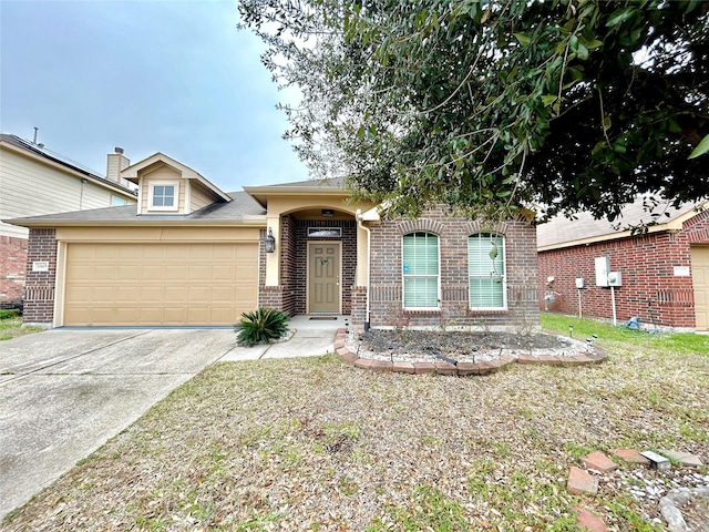 view of front of house featuring driveway, a garage, and brick siding