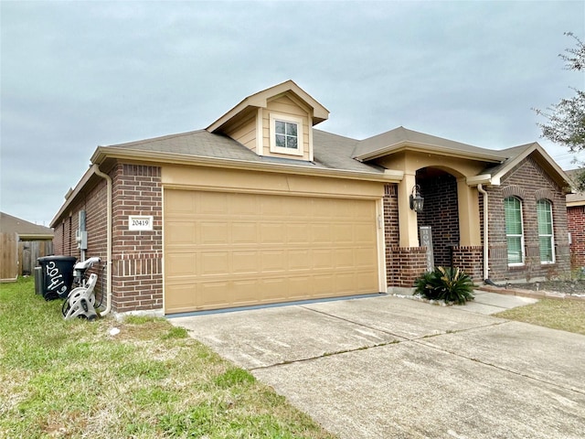 view of front of property with driveway, brick siding, and an attached garage