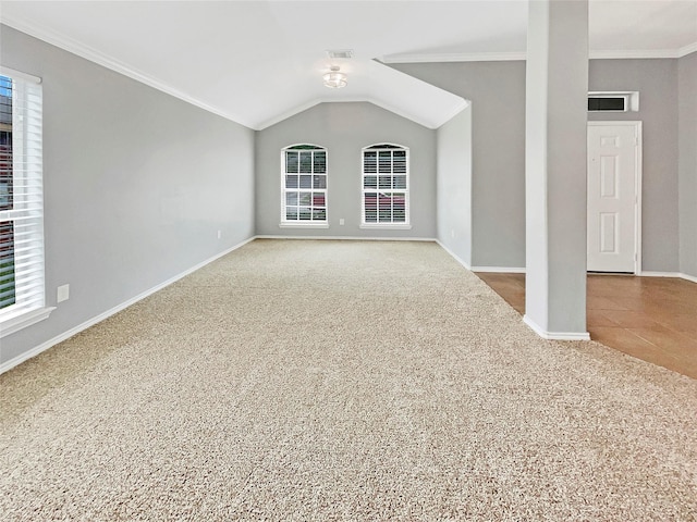 spare room with carpet, crown molding, visible vents, vaulted ceiling, and baseboards