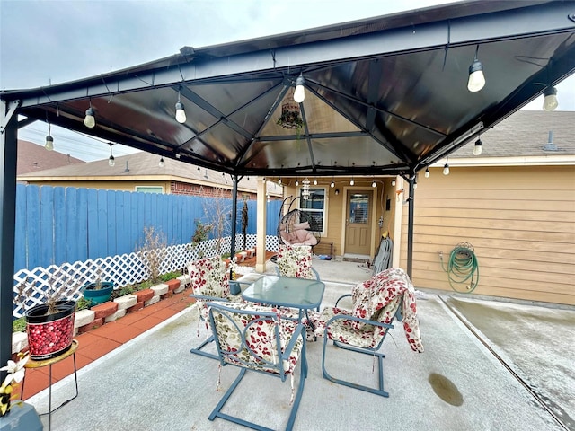 view of patio / terrace featuring outdoor dining area, fence, and a gazebo