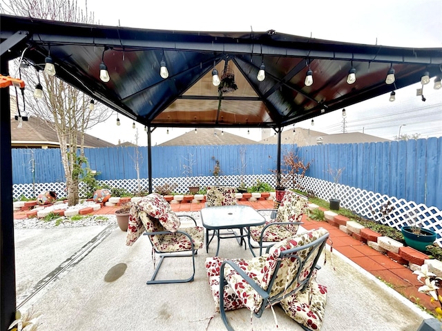 view of patio with a gazebo, outdoor dining area, and a fenced backyard