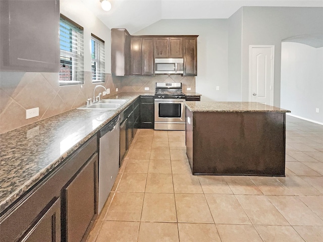 kitchen featuring appliances with stainless steel finishes, a center island, a sink, and light tile patterned floors