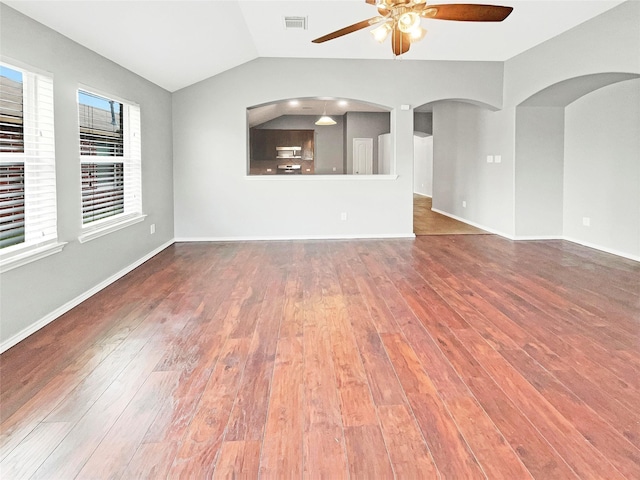 unfurnished living room featuring ceiling fan, hardwood / wood-style flooring, visible vents, baseboards, and vaulted ceiling