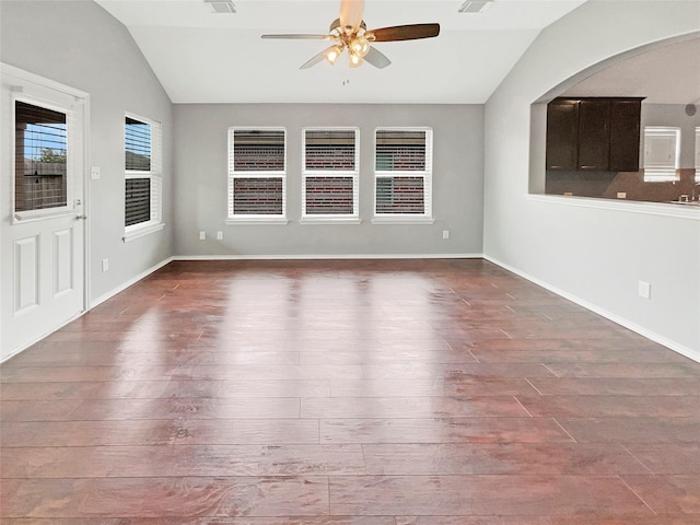 spare room with vaulted ceiling, wood finished floors, a ceiling fan, and baseboards