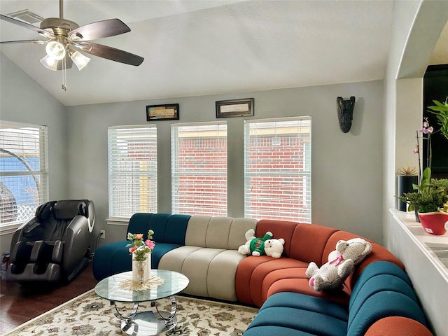 living area with a ceiling fan, visible vents, vaulted ceiling, and wood finished floors