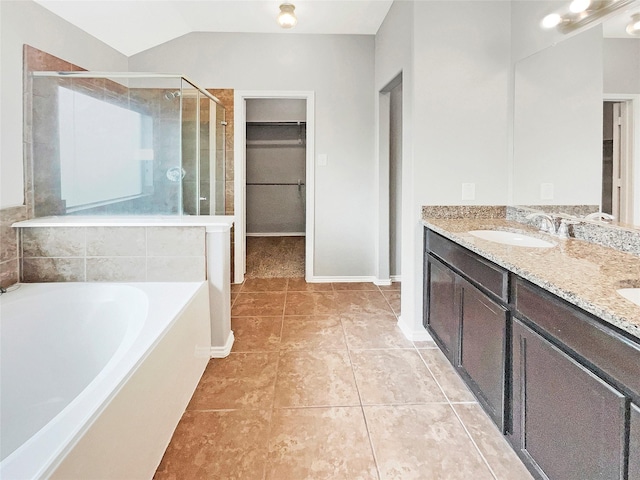 bathroom featuring a garden tub, tile patterned flooring, a spacious closet, a shower stall, and a sink