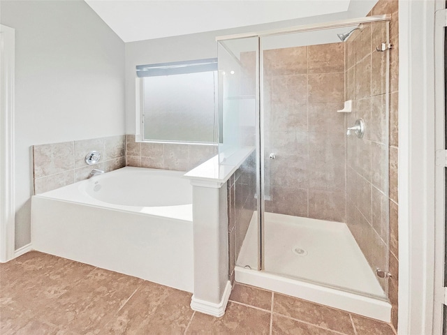 bathroom featuring a stall shower, tile patterned flooring, and a garden tub