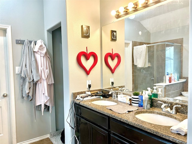 full bathroom with a stall shower, a sink, and double vanity