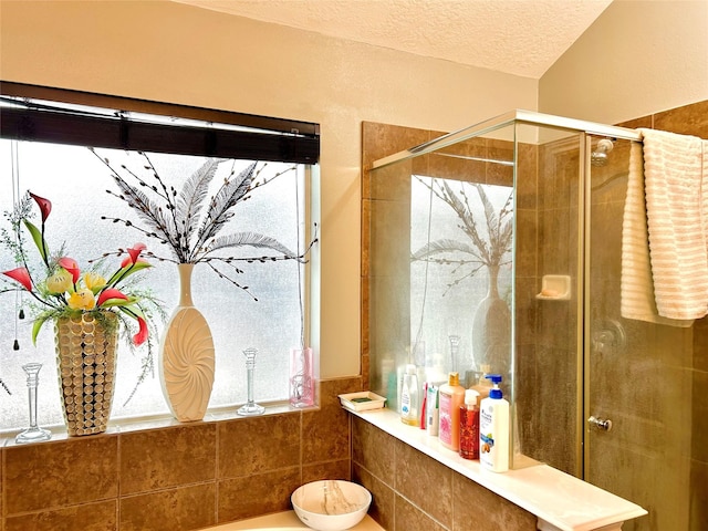 bathroom with a stall shower and a textured ceiling