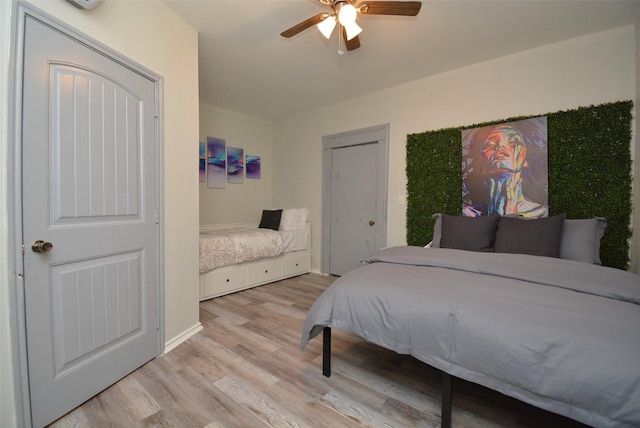 bedroom with wood finished floors, a ceiling fan, and baseboards