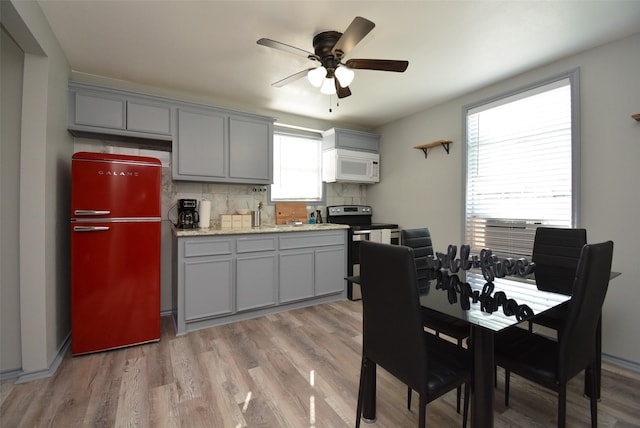 kitchen featuring gray cabinetry, stainless steel electric range, and freestanding refrigerator