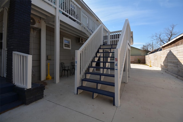 view of patio featuring stairs and fence