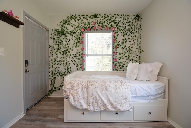 bedroom featuring baseboards and wood finished floors