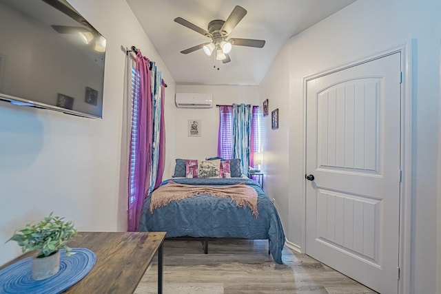 bedroom with an AC wall unit, ceiling fan, and light wood-style flooring