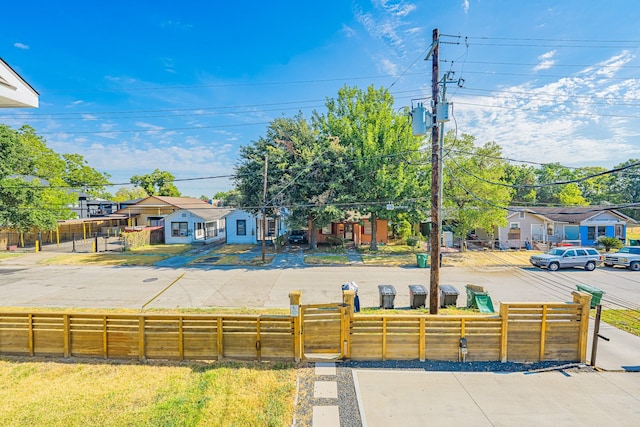 view of front of house with a fenced front yard, a residential view, and a gate