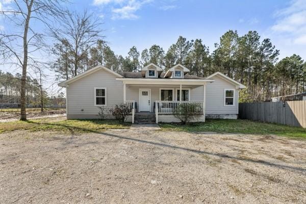 bungalow-style home featuring a porch, crawl space, and fence