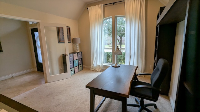 office space featuring light carpet, baseboards, and lofted ceiling