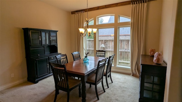 dining area with light carpet, baseboards, and an inviting chandelier