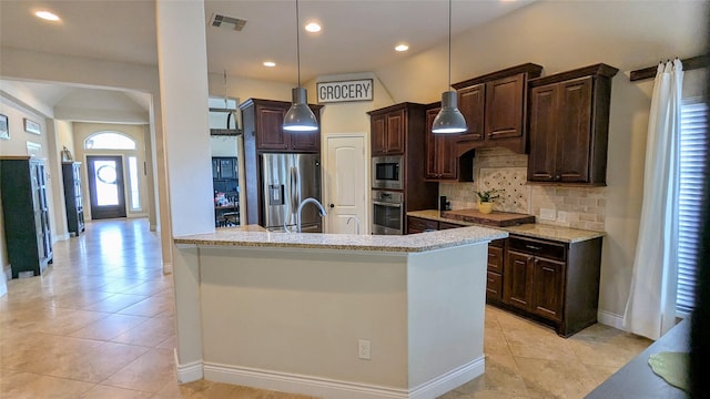 kitchen featuring visible vents, pendant lighting, appliances with stainless steel finishes, decorative backsplash, and dark brown cabinets