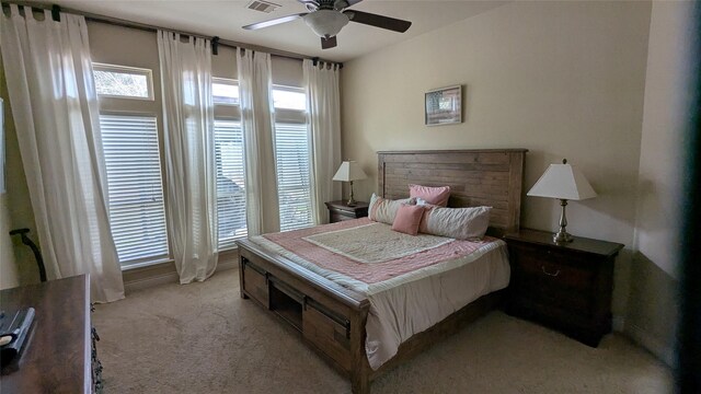 bedroom featuring visible vents, light colored carpet, and ceiling fan