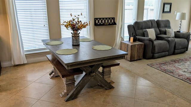 dining space featuring light carpet and light tile patterned flooring