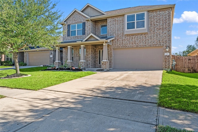 craftsman house featuring brick siding, fence, a front yard, a garage, and driveway