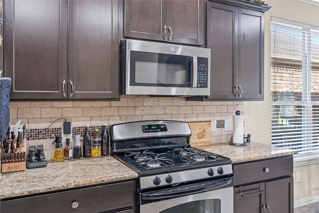 24111 Auburn Woods Ct, Porter, TX 77365 - kitchen featuring appliances with stainless steel finishes, dark brown cabinets, healthy amount of natural light, and decorative backsplash