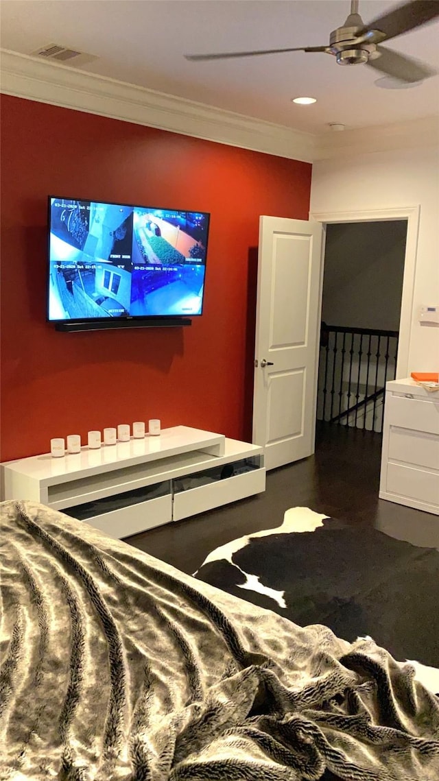 bedroom featuring a ceiling fan, visible vents, and crown molding