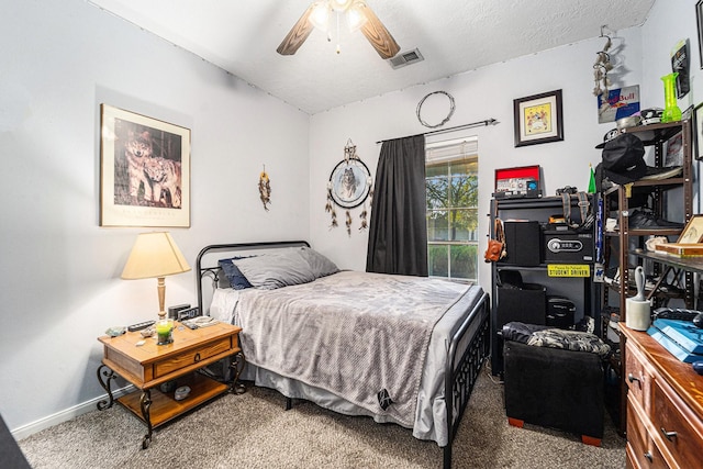 carpeted bedroom featuring a ceiling fan, visible vents, a textured ceiling, and baseboards