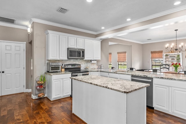 kitchen with visible vents, white cabinets, dark wood-type flooring, stainless steel appliances, and a sink