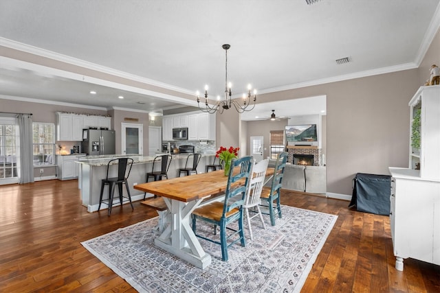 dining area featuring a warm lit fireplace, plenty of natural light, visible vents, and dark wood-type flooring