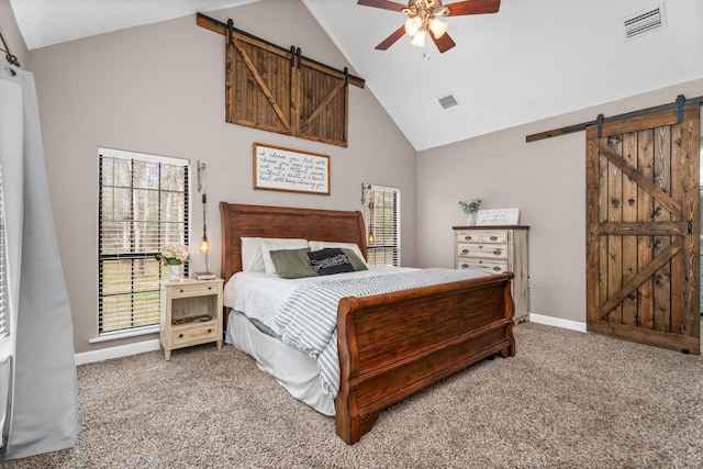 carpeted bedroom with high vaulted ceiling, a barn door, and visible vents