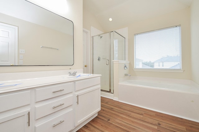 full bath with a garden tub, a sink, wood finished floors, a shower stall, and double vanity