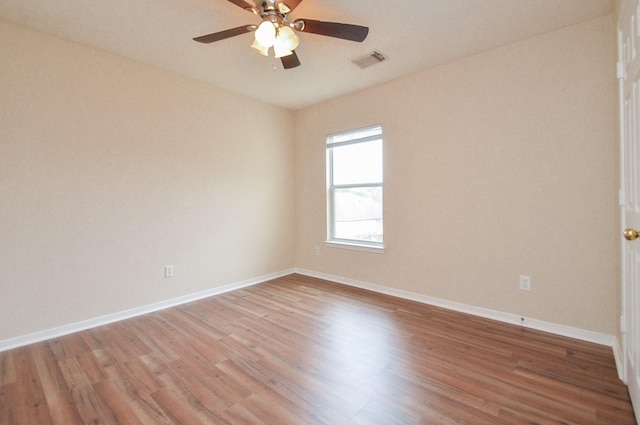 spare room with light wood-style floors, visible vents, ceiling fan, and baseboards