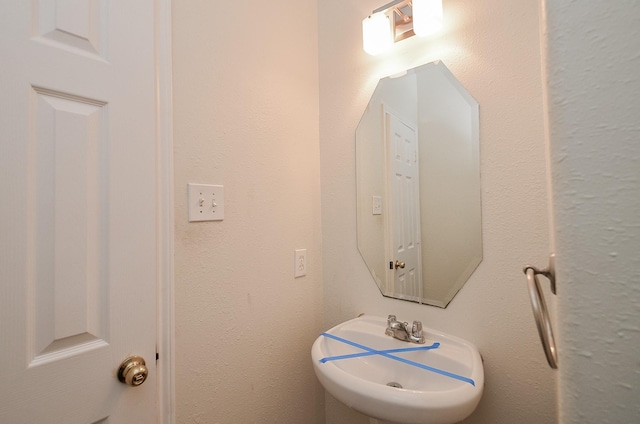 bathroom featuring a sink and a textured wall