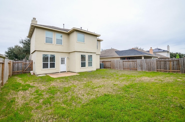 rear view of property featuring a chimney, a lawn, central AC unit, a patio area, and a fenced backyard