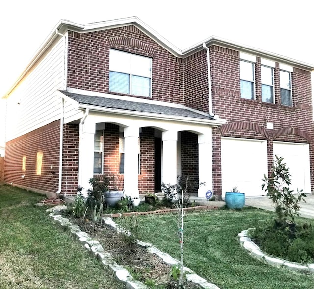 view of front of house featuring brick siding, covered porch, a front yard, a garage, and driveway