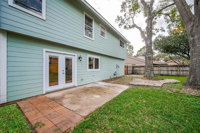 rear view of house with a yard, french doors, a patio area, and fence