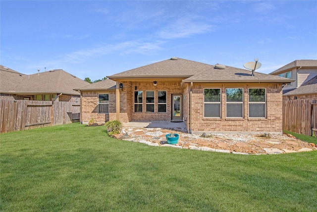 rear view of property with a yard, a fenced backyard, and brick siding